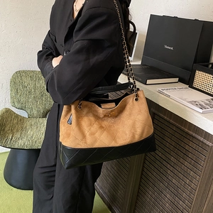 Quilted suede bucket tote bag in brown and black leather with gold chain strap