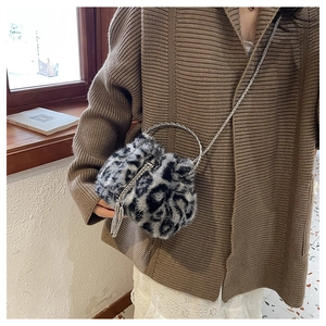 Detail of faux fur leopard bucket bag with silver ring handle and chain strap