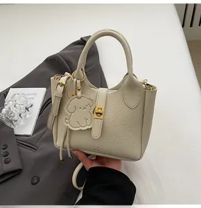 Close-up of litchi pattern leather bucket bag with gold hardware and logo engraving