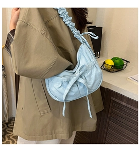 Close-up of light blue nylon bag featuring a bow decoration and ruffled shoulder strap