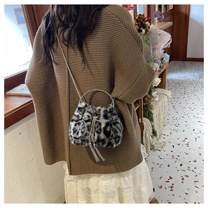 Leopard print faux fur bucket bag shown worn crossbody on model for style reference