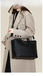 Détails du sac cabas noir grainé avec poignées tressées et clous de fond en métal