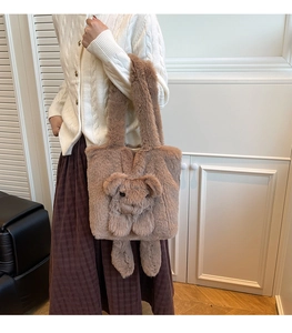 Close-up of fluffy brown plush tote bag with cute animal decoration worn by a model