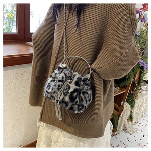 Detail of plush leopard print bucket bag with silver ring handle and tassel drawstring