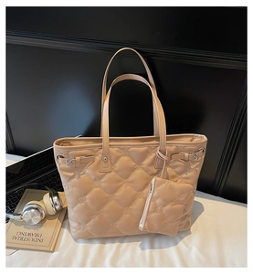 Détail du sac cabas matelassé abricot avec gaufrage floral et petit porte-monnaie