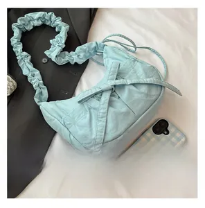 Detail of light blue pleated nylon shoulder bag with bow knot and ruffled strap