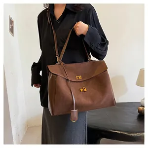 Détail du sac cabas marron foncé en daim avec cuir lisse et fermoir doré chic