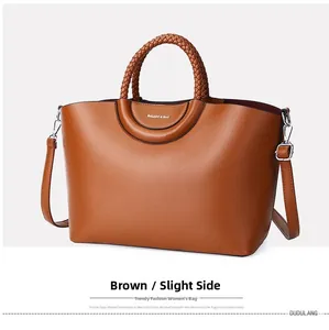 Détail du cabas en cuir marron avec poignées tressées et lettrage de la marque BALADO