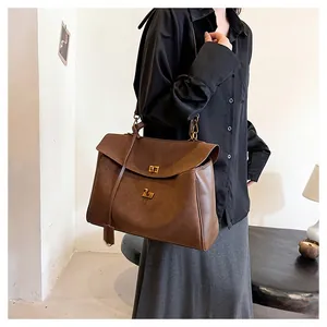 Détail du grand sac cabas marron foncé avec fermoir doré et bandoulière réglable
