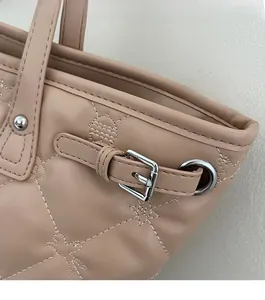 Détail du matelassage en étoile du sac fourre-tout beige avec boucle argentée et clous