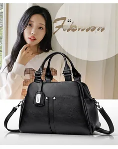 Detail of black pebbled leather Boston bag with metal studs and adjustable shoulder strap