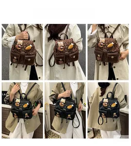 Detailed views of leopard print and black leather backpacks with cute 3D cartoon charms