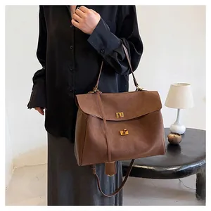 Détail du sac cabas marron vintage avec fermoir doré et texture en daim doux