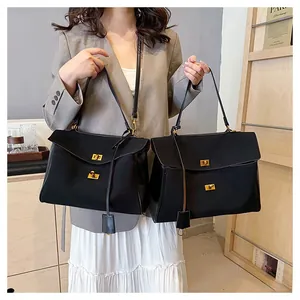 Détail de sacs fourre-tout noirs avec ferrures dorées et breloques en cuir en intérieur