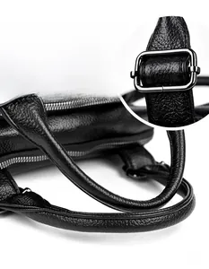 Close-up of litchi grain leather texture and silver metal hardware on a Boston bag