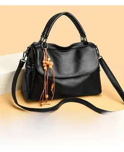 Detailed macro view of black lychee grain leather bag with wooden bead tassel accent