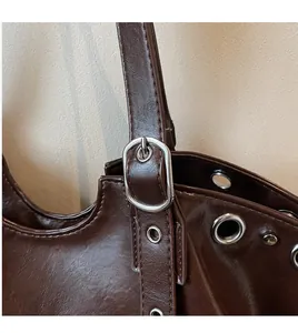 Macro view of dark brown leather strap with silver metal buckles and eyelet details
