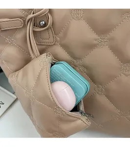 Détail du sac cabas beige matelassé avec une petite pochette zippée assortie de rangement