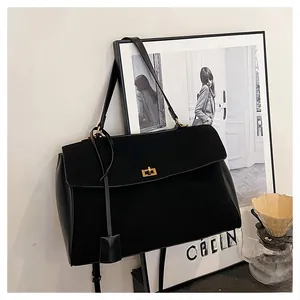Détail du sac cabas noir avec texture mate et fermoir doré élégant