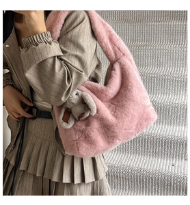 Pink plush tote bag detail with cute grey rabbit pendant and soft faux fur texture