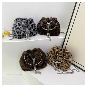 Detail view of leopard print bucket bags with metallic chain straps and fringe rings