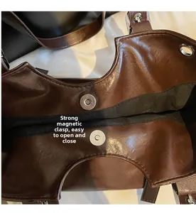 Detail of the strong magnetic snap closure on a dark brown leather shoulder bag