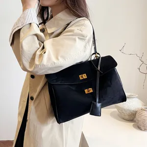 Détail du sac cabas en daim noir avec double fermoirs dorés et pendentif en cuir