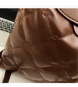 Detail shot of brown quilted leather backpack featuring star and flower embroidery