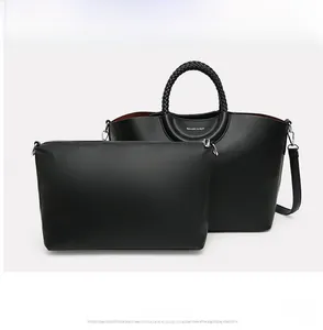 Détail de l'ensemble sac fourre-tout et pochette noire en cuir grainé avec poignées