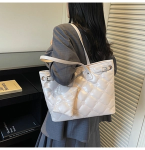 Vue latérale d'un grand sac cabas matelassé beige avec détails fleuris sur un mannequin