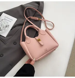 Detail of pink lychee pattern leather bucket bag with gold hardware and embossed text