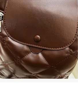 Detail shot of diamond quilted dark brown leather with equestrian knight embroidery