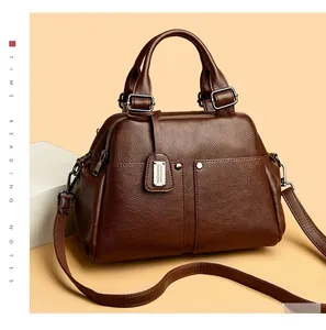 Close-up of deep brown pebble grain leather and silver metal hardware on Boston bag