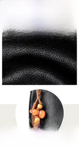 Detailed view of black wax leather texture with a decorative beaded gourd pendant