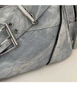 Gros plan détaillé du tissu denim bleu clair avec boucle argentée et fermeture éclair noire