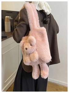 Detailed view of a pink plush teddy bear shoulder bag on a model in a cafe setting