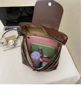 Macro view of brown quilted leather backpack interior showing large storage capacity