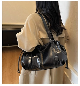 Vue latérale détaillée du grand sac cabas noir en simili cuir porté avec trench