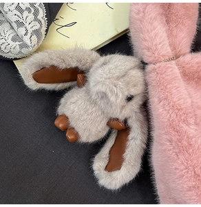 Close-up of a plush bunny charm in grey-brown faux fur with a durable metal chain