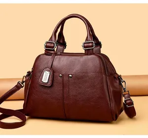 Detail of lychee textured leather and metal rivets on dark burgundy Boston bag