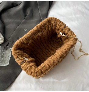 Close-up of brown knit texture and gold chain strap on minimalist crossbody bag