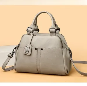 Detailed macro view of high-quality lychee grain leather and gunmetal hardware on Boston bag