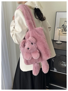 Detail of pink plush tote bag with bear motif and rabbit ears in a cozy setting