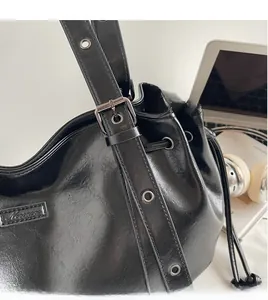 Detail of adjustable leather strap with silver metal eyelets and drawstring closure