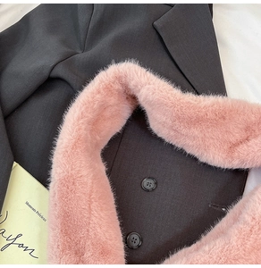 Detail of double-breasted black coat featuring a plush pink faux fur collar and matte buttons