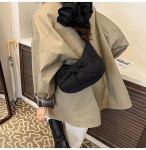 Detail of black pleated nylon bag featuring a large decorative bow and puffed cloud texture