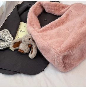 Close-up of pink fluffy plush tote bag with a cute long-eared bunny rabbit charm accessory