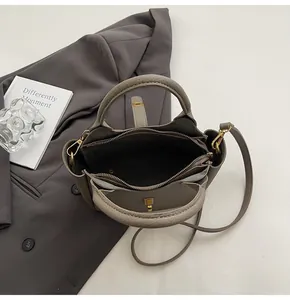 Top view of taupe lychee leather bucket bag showing three internal compartments and zippers