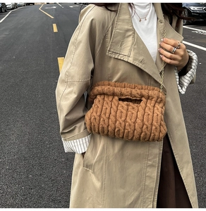 Detailed cable-knit texture of a brown knit crossbody bag with golden chain strap