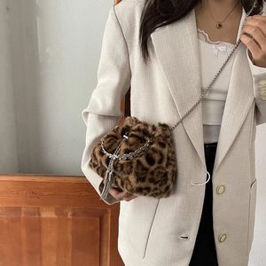 Faux fur leopard print bucket bag with silver chain strap worn under the arm fashionably